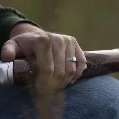 The Classic 5mm Barrel Band with a silver platinum insert holding a shotgun.