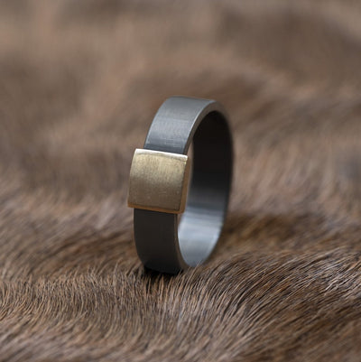 The Gunmetal 7mm Barrel Band with a yellow gold insert. The Barrel Band is the first wedding ring cut directly from a shotgun Barrel.