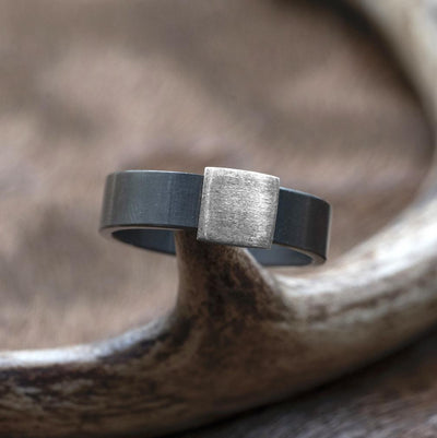 The Gunmetal 7mm Barrel Band with a silver platinum insert. The Barrel Band is the first wedding ring cut directly from a shotgun Barrel.