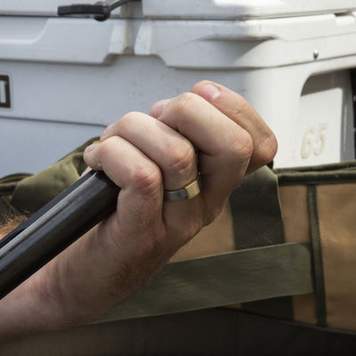 The Classic 7mm Barrel Band with a yellow gold insert holding a shotgun.