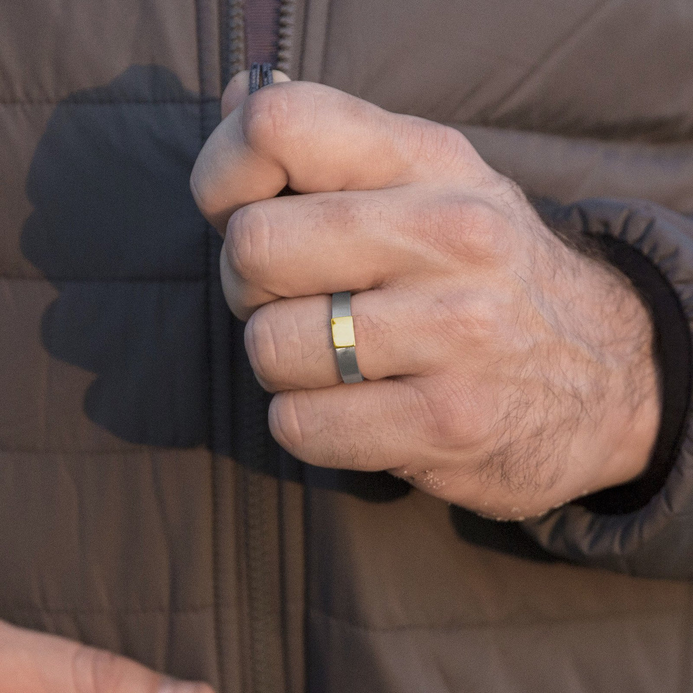 The Classic 5mm Barrel Band with a yellow gold insert sipping up jacket.